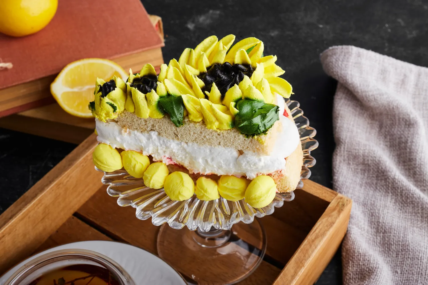 A slice of lemon lush dessert on a glass plate. Topped with whipped cream and yellow frosting.