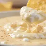 Tortilla chip dipped into cottage cheese queso