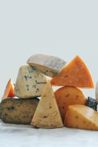 Close-up of blue cheese with visible blue veins and a creamy texture on a wooden board