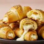 Golden crescent roll appetizers with melted cheese and poppy seeds