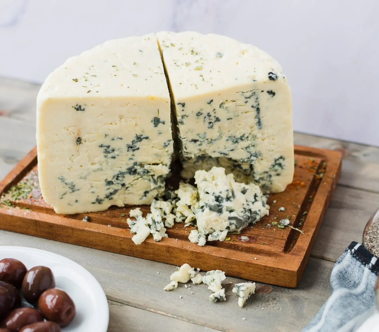 Close-up of blue cheese with visible blue veins and a creamy texture on a wooden board