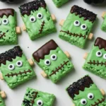 Overhead shot of Frankenstein Halloween Rice Krispie Treats decorated with green candy melts, candy eyes, and black sprinkles
